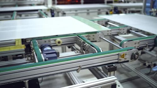 Close-up work of automated equipment for producing solar panels.