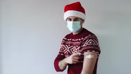 Man in Christmas Hat With Arm Band-aid