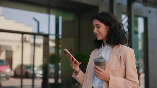 Side View of the Busy Smiling Businesswoman Walks with Coffee to Enter Office Building Using