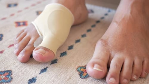Experience Comfort By Wearing a Bunion Corrector on your Foot As you Walk on the Carpet