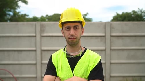 A Construction Worker, Wearing a Yellow Hard Hat with Standard Safety Spectacles Positioned on His N