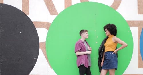 Millennials standing ne,t to colourful wall