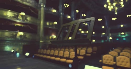 Concert Hall with Empty Seats and Music Stand in Focus During Evening Event