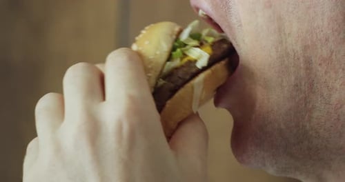 Man Eats Hamburger Close Up