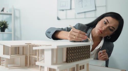 Professional young architect engineer measure house model length. Immaculate.