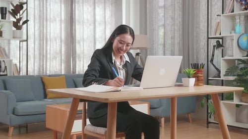 Young Woman Works at Laptop in Home Office
