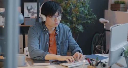 Young Adult Typing at Computer in Modern Office