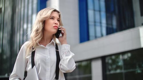 Confident Blonde Successful Businesswoman with Smartphone Wearing Suit Standing on City Street