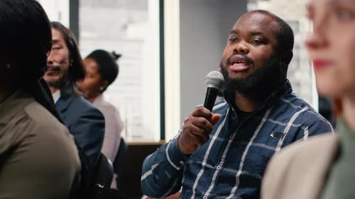 Man with Microphone Speaks at Corporate Conference