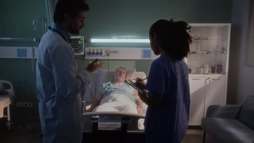 Doctor and Nurse Conferring About Patient in Hospital