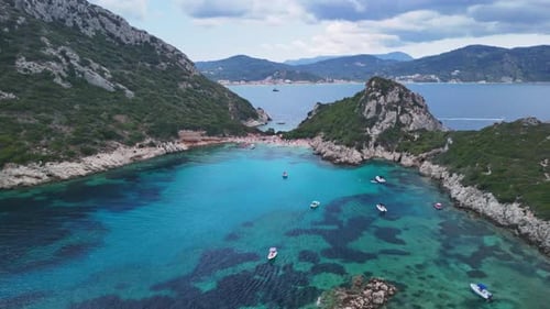 Majestic Aerial View of Turquoise Bay with Boats and Rugged Mountains