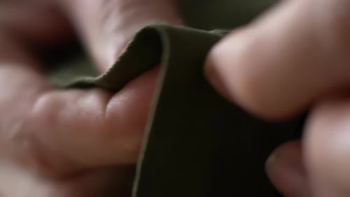 Close Up of Hands Sewing Dark Green Fabric