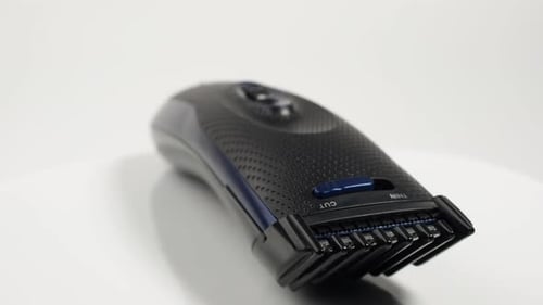 El cortapelos gira sobre un fondo blanco. Cortadora de pelo moderna.