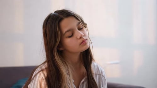 Teenage Girl with Brown Hair Resting Indoors on Sofa