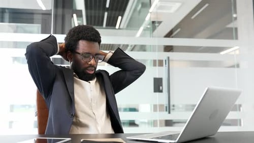 Happy african american businesswoman finished work on laptop sitting at workplace in office