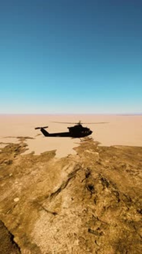 Military Helicopter Flying Over Barren Landscape