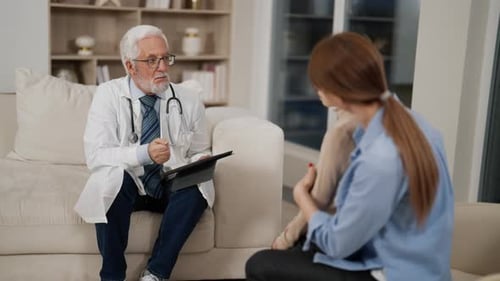 Senior Doctor Consults Family in Clinic Professional Pediatrician Talking with Mom Son Looking at