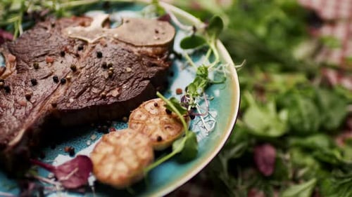 Gegrilltes T-Bone-Steak, das sich auf dem Tisch dreht, mit frischem Grün