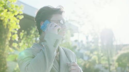 At Sunlight Man with Glasses Talking on a Mobile Phone in a City Confident Young Businessmen Have