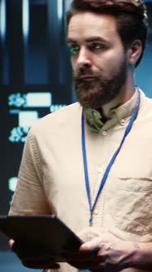 Bearded Man Working in Dark Server Room