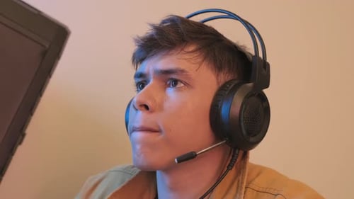 Young Man With Headset Looking at Monitor