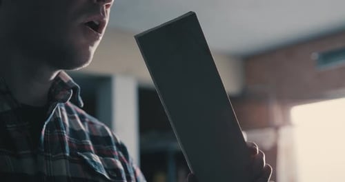 Man Blowing Dust Off Piece of Wood