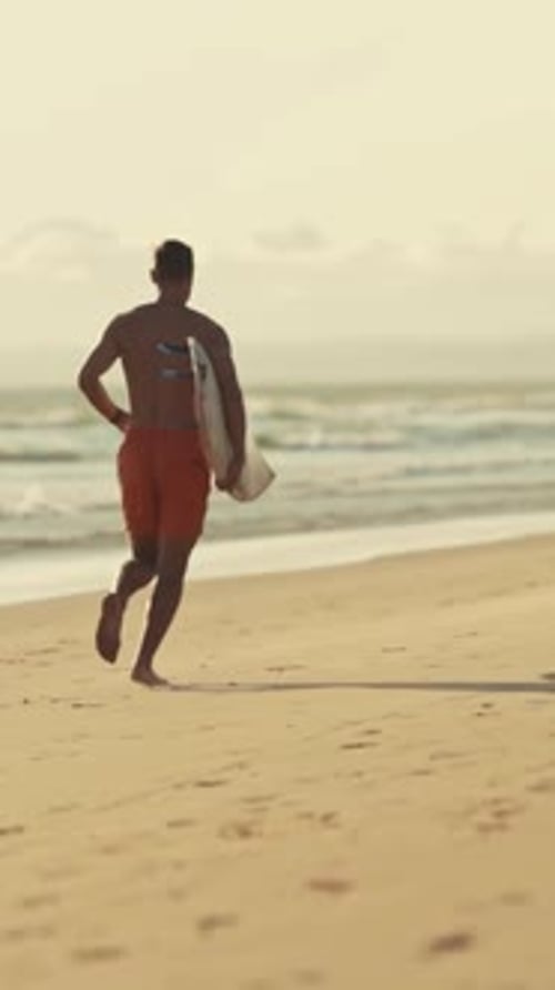 Surfer Running on the Beach at Sunset