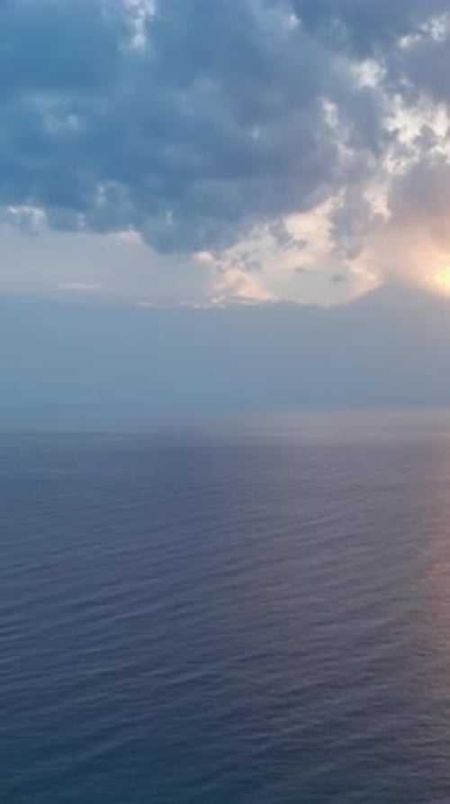Vidéo verticale : vue aérienne d'un coucher de soleil méditerranéen au crépuscule avec une lumière dorée à l'horizon