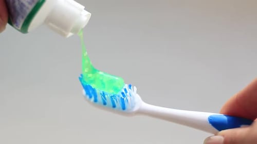 Applying Green Toothpaste to a Toothbrush for Daily Dental Care
