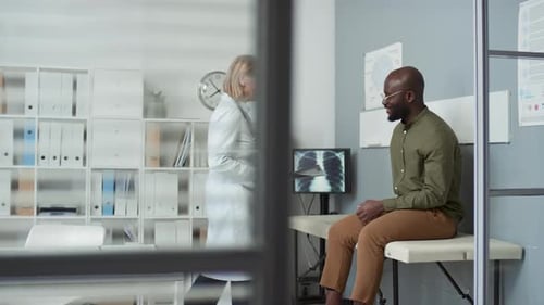 Confident Clinician Explaining Patient Result of Lung X-ray in Hospital