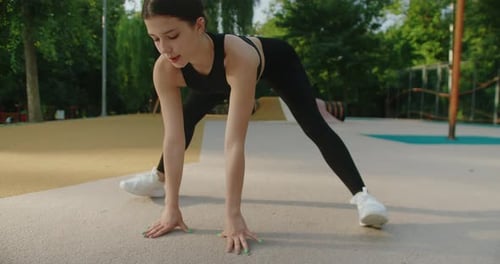 Woman Stretching Legs in Urban Park Daytime