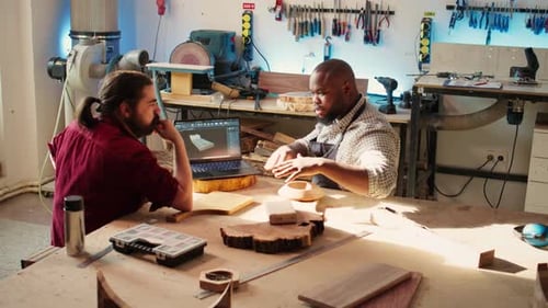 Woodworkers Designing Custom 3D Furniture on Notebook in Studio