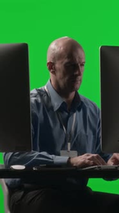 Programmer Using Computer with Dual Monitor against Chroma Key Background
