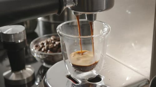 Espresso Pours From a Coffee Machine into Glass