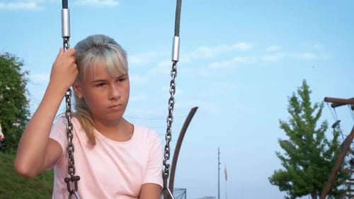 Thoughtful Teen on Alone Swing on Playground
