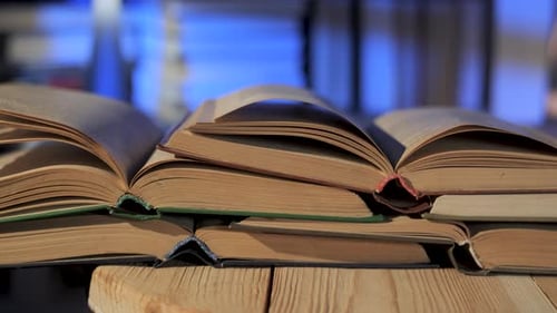 Old Books Stacked Open on Wooden Table