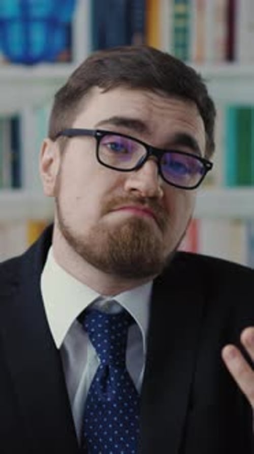 Man in Suit Talking with Bookshelf Background