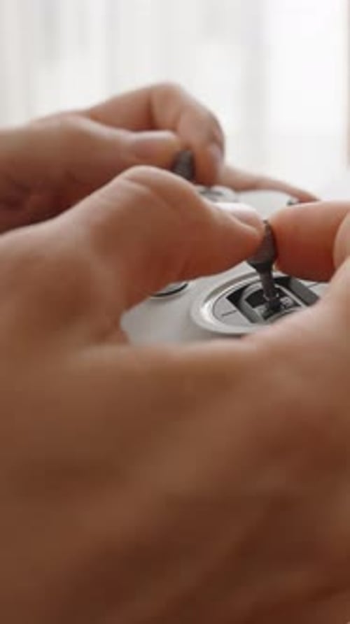 Vertikales Video. Person, die ein Kabel in der Nähe des Laptops hält und in den FPV-Drohnen-Joystick-Controller einsteckt