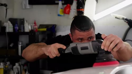 Closeup View of a Concentrated Mechanic Buffing a Car Hood Engaging in Detailed Automotive Work