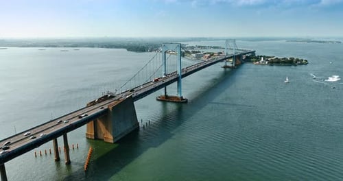 Cars ride by the suspension bridge over East River. Beautiful top view of the Throgs Neck Bridge