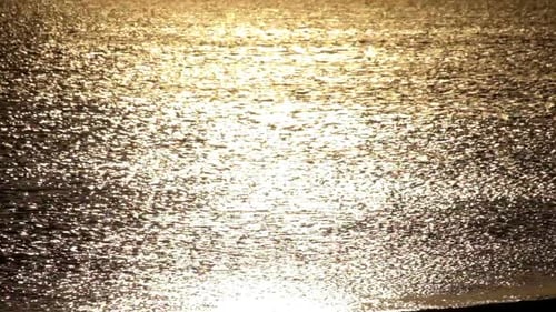 Golden sunlight shimmers across the ocean waves at sunset