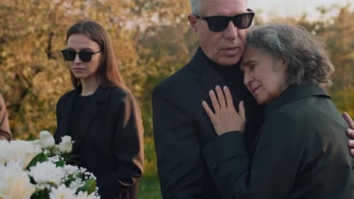 Mourning Family Embraces at Funeral