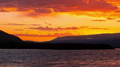 Dramatic Sunset Over Ocean and Mountains Epic Warm Clouds in Sky Moving in Timelapse Iceland