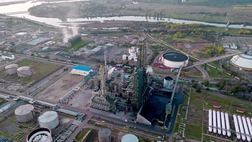 Orbe aérienne d'une raffinerie de pétrole et de sa tour de fractionnement avec les réservoirs en arrière-plan, natura