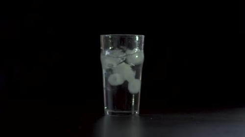 Ice Cubes Falling Into a Glass of Water