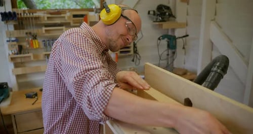 A Young Man is Working on a Homemade Milling Machine in His Woodworking Workshop
