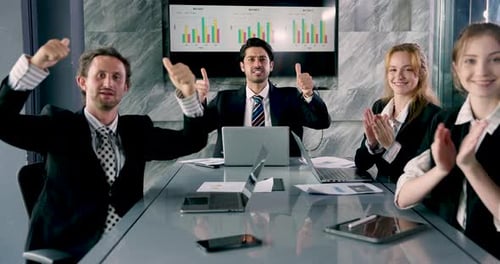 Diverse business team clapping hands during office meeting celebrating successful collaboration,