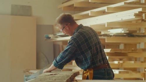 Man sawing wood in workshop