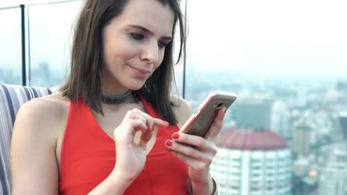 Young, Elegant Woman Surfing Internet On Smartphone Sitting On Terrace In Bar