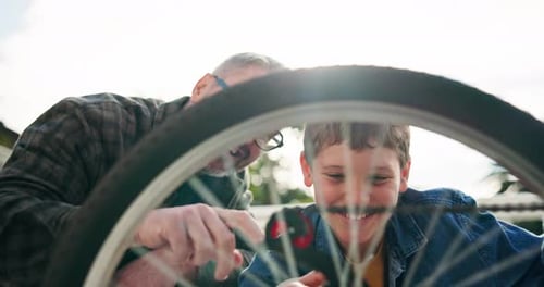 Boy and Man Repair Bike Wheel Together